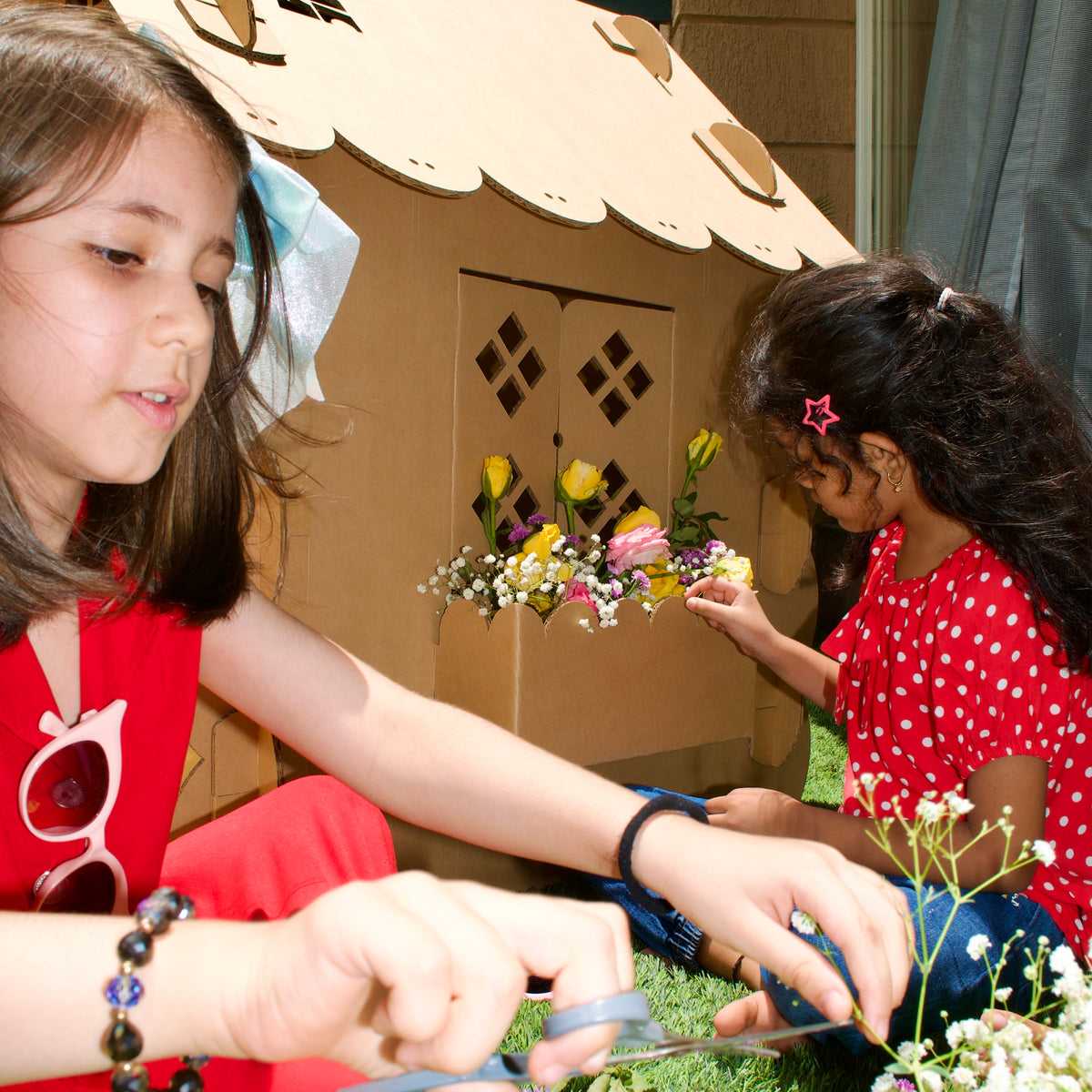 Children arranging real flowers in the flower box of a DUDUK Cubby House
