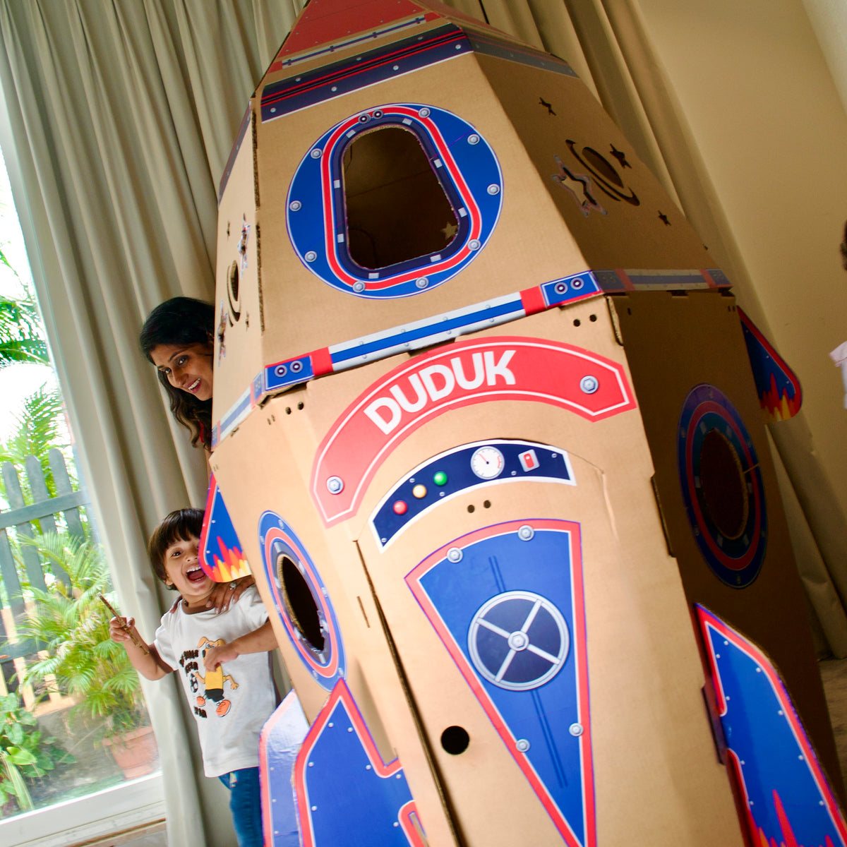 Boy and his mother peeking out from behind a 170 cm DUDUK Rocket
