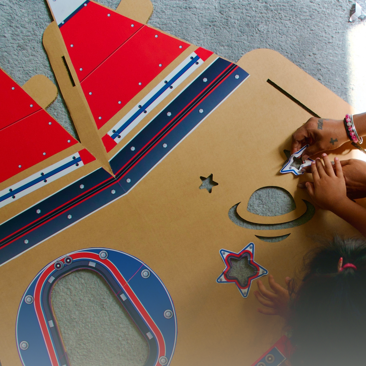 Child decorating a DUDUK Rocket with the space sticker pack