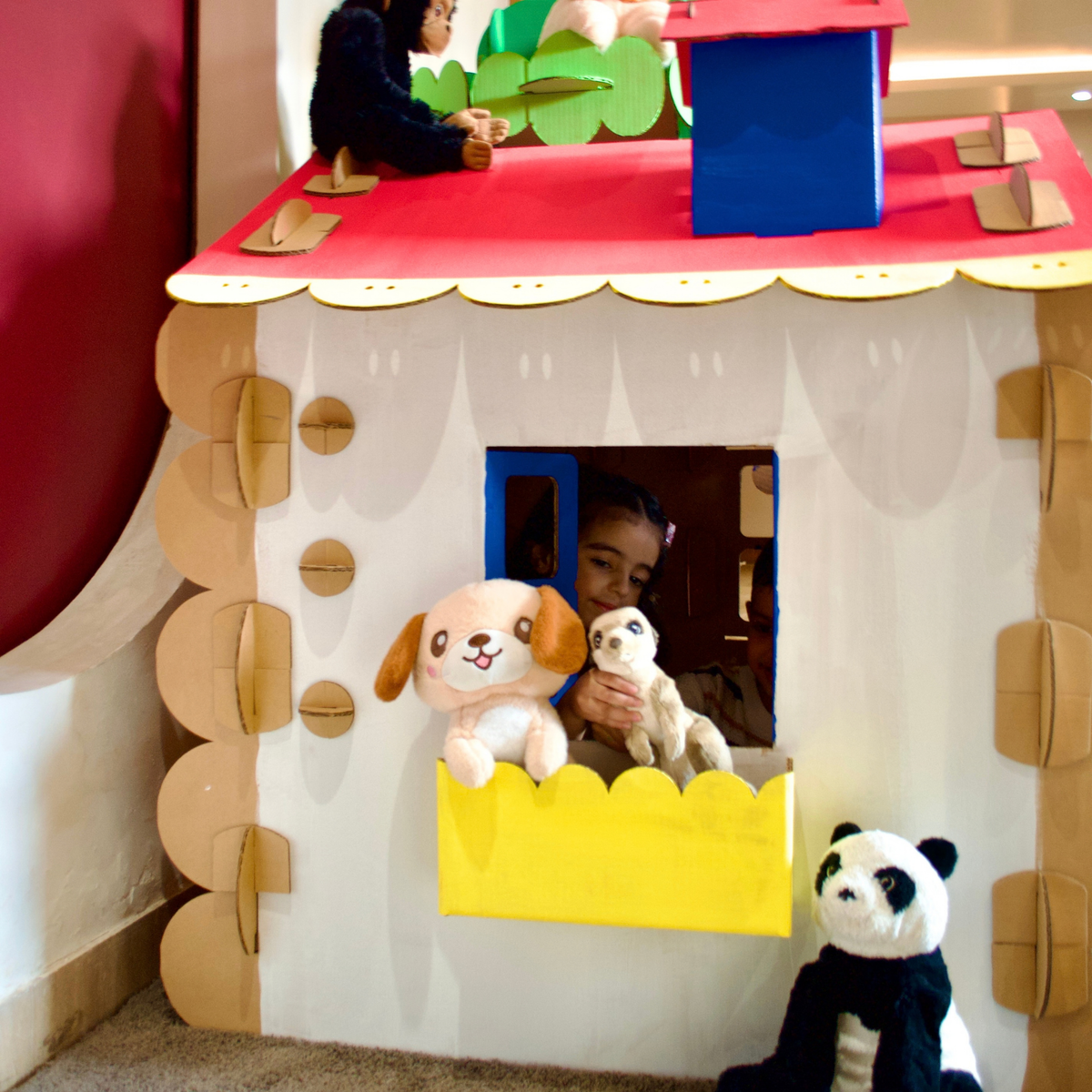 Window box with soft toys under the painted red roof of a DUDUK Tree House