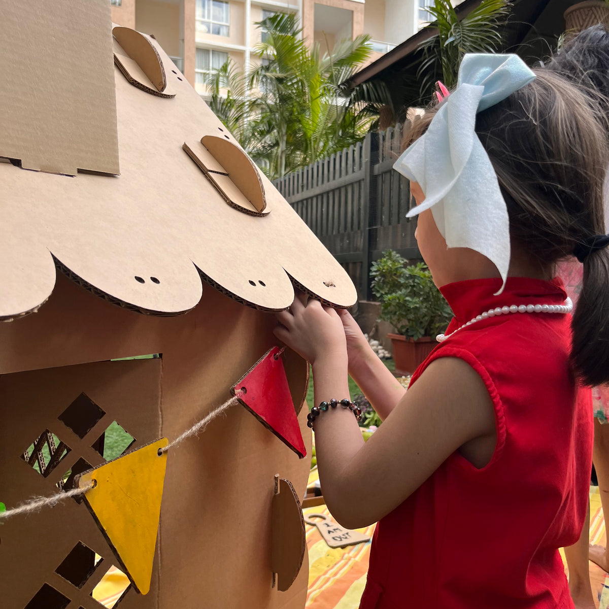 Child hanging bunting flags on a DUDUK Cubby House