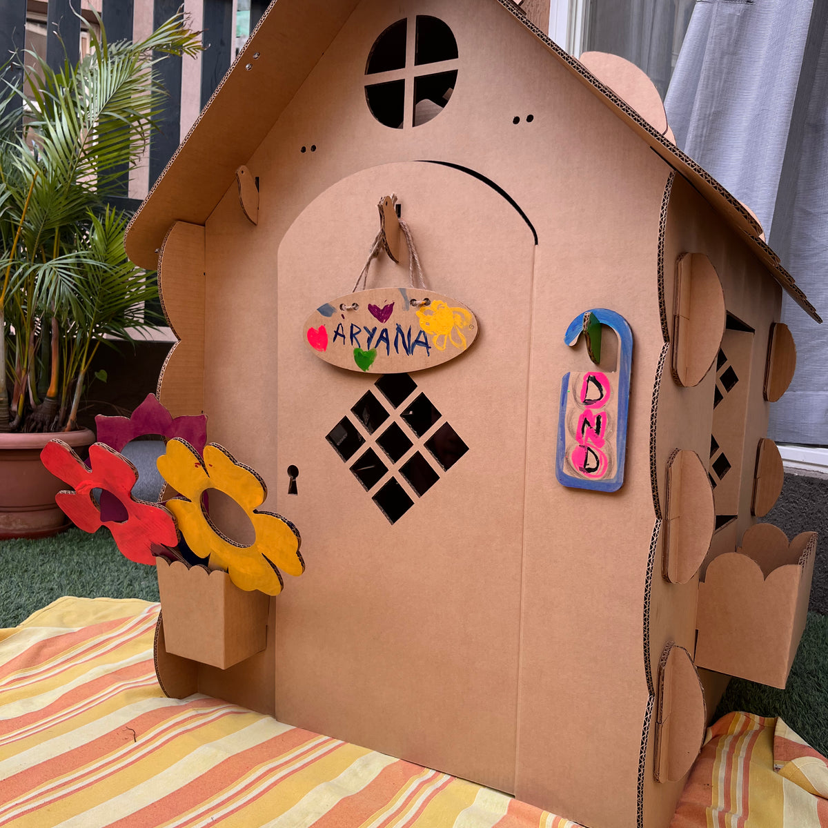 Front of a DUDUK Cubby House decorated with bunting and flowers