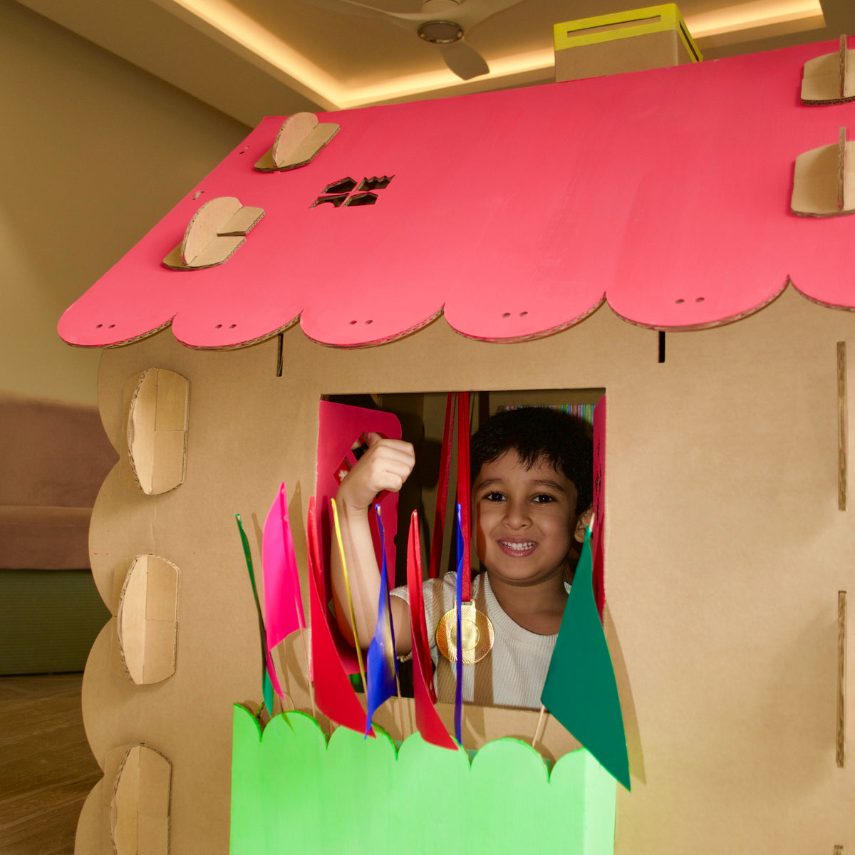 Boy at the window of his football-themed DUDUK Cubby House with pennants