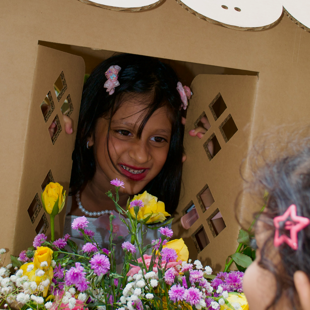 Girl at the window of her DUDUK cubby house with a painted flower box in bloom