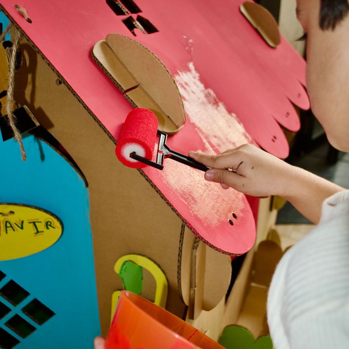Child painting a DUDUK Cubby House roof with the Painting Kit