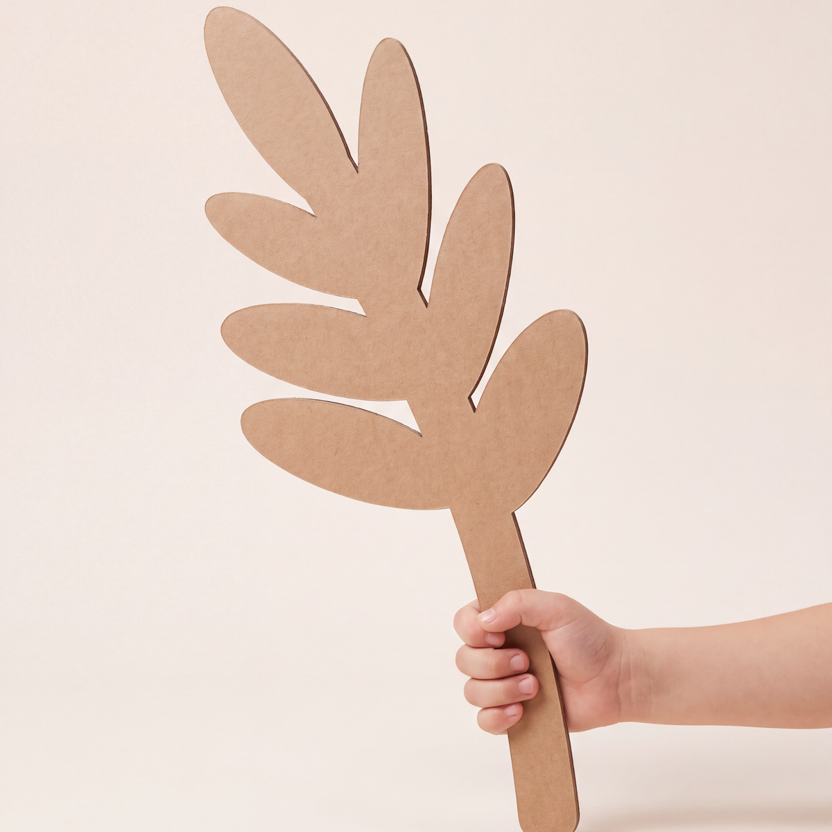 Child holding a DUDUK Flower Kit leaf frond