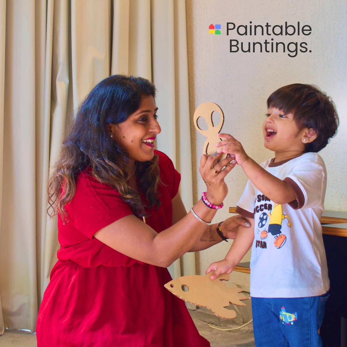 Boy and his mother with space-themed paintable buntings for the DUDUK Rocket