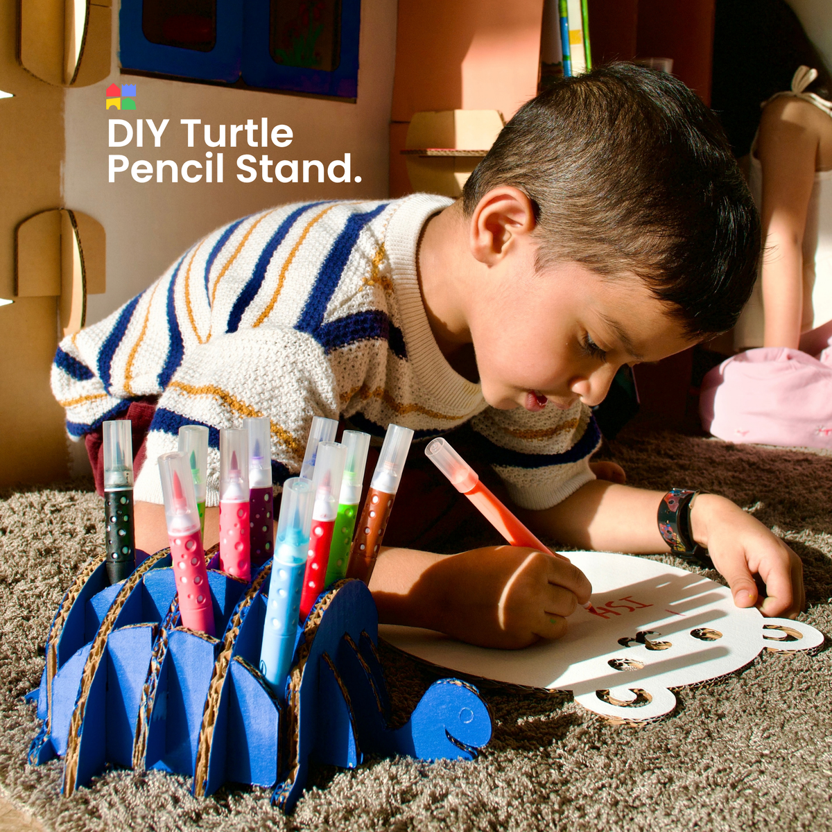 Boy drawing beside a DUDUK Tree House with a DIY turtle pencil stand